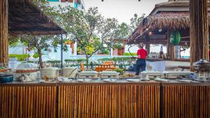 a man standing in front of a table with food at Hotel Villa AoKhanom Beachfront in Khanom