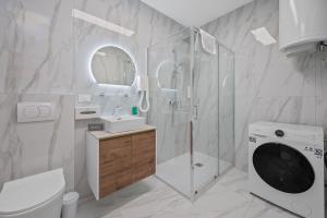 a bathroom with a shower sink and a washing machine at Apartmani Point Pregrada in Pregrada