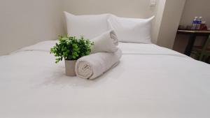 a white bed with a potted plant on it at Swing and Pillows - Jalan Changkat Thambi Dollah in Kuala Lumpur +13 photos