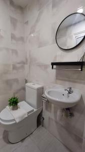a bathroom with a toilet and a sink and a mirror at Swing and Pillows - Jalan Changkat Thambi Dollah in Kuala Lumpur