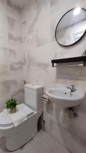 a bathroom with a toilet and a sink and a mirror at Swing and Pillows - Jalan Changkat Thambi Dollah in Kuala Lumpur