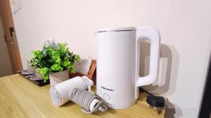 a coffee maker sitting on a table next to a plant at Swing and Pillows - Jalan Changkat Thambi Dollah in Kuala Lumpur