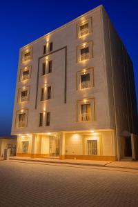 a large white building with windows at night at روضة طيبة السكنية شقة قريبة من الحرم in Al Madinah