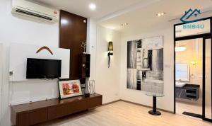 a living room with a tv on a wall at Landed Spacious House at Cangkat Delima Gelugor Penang in Gelugor