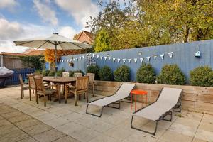 HindolvestonにあるFinest Retreats - The Chapelのテーブルと椅子と傘のあるパティオ