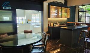 a kitchen with a table and a counter top at Landed Spacious House at Cangkat Delima Gelugor Penang in Gelugor +14 photos