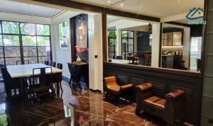 a restaurant with a table and chairs and a mirror at Landed Spacious House at Cangkat Delima Gelugor Penang in Gelugor