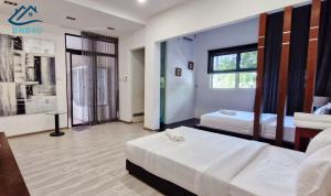 a bedroom with two beds and a window at Landed Spacious House at Cangkat Delima Gelugor Penang in Gelugor