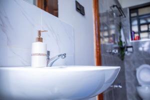 un lavandino del bagno con un distributore di sapone sopra di Most Executive house in Naka Lakeview & central a Nakuru Altre 23 foto
