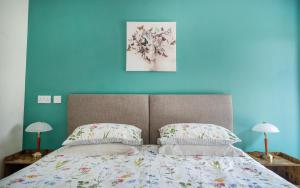 奥福德Barclay’s But n Ben的一间卧室设有蓝色的墙壁和一张带枕头的床。