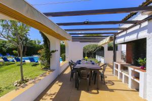 a patio with a table and chairs under a pergola at Villa ADELFA in Salou