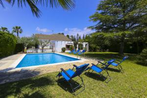 a group of blue chairs sitting next to a swimming pool at Villa ADELFA in Salou