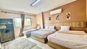 une chambre avec deux lits et une fenêtre dans l'établissement Moon Homes in Downtown Cairo, au Caire