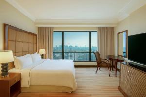 a hotel room with a bed and a large window at The Westin Dhaka in Dhaka
