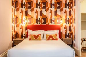 1 cama con cabecero rojo y 2 almohadas en The Originals Boutique, Hôtel Normandie, Auxerre, en Auxerre