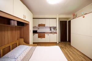 een kleine slaapkamer met een bed en een keuken bij Mono Villaggio Del Sole in Limone Piemonte