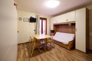 een kamer met een bed en een tafel en een bed en een slaapkamer bij Mono Villaggio Del Sole in Limone Piemonte