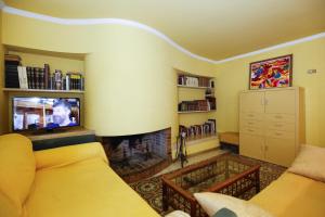 a living room with a yellow couch and a fireplace at Villa COCOCHA in Salou