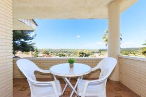 ein weißer Tisch und zwei weiße Stühle auf einem Balkon in der Unterkunft Villa GOLETA in Ferrán