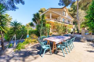 ein Tisch und Stühle vor einem Haus in der Unterkunft Villa GOLETA in Ferrán