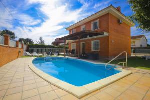 a swimming pool in front of a house at PLUMA VILLA - Only Families in Salou