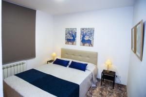 a bedroom with a bed and two paintings on the wall at PLUMA VILLA - Only Families in Salou +20 photos