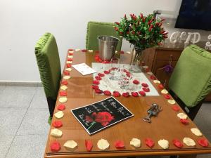 een tafel met rode rozen en een boek erop bij Apartmento in Vecindario