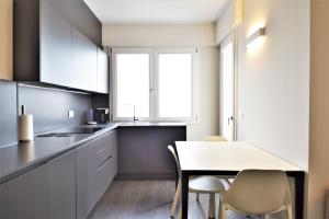 a kitchen with white cabinets and a table and chairs at Venice Terminal Apartments & Suites in Mestre +42 photos