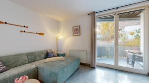 a living room with a couch and a sliding glass door at strandnahe FeWo mit Schwimmbad im Haus, a cappella 68,Binz in Binz