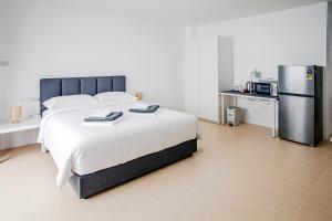 a bedroom with a large bed and a refrigerator at Stay White Orchid in Krabi