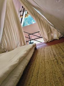 a mattress in a tent with a bed in it at Rustic Palms in Thāl