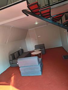 a living room with a couch and a table at Rustic Palms in Thāl +5 photos