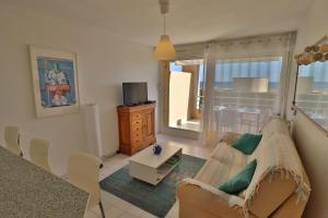 un soggiorno con un divano e una TV di Lagune Azur – Séjour cosy vue mer avec Wi-Fi a Sète