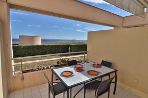 un tavolo e sedie su un balcone con vista sull'oceano di Lagune Azur – Séjour cosy vue mer avec Wi-Fi a Sète