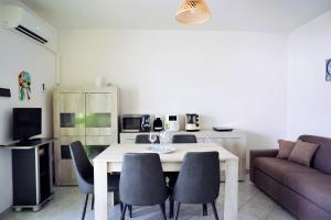 een woonkamer met een tafel, stoelen en een bank bij A Casa di Doralucia - Comfort a Santa Maria di Leuca in Leuca