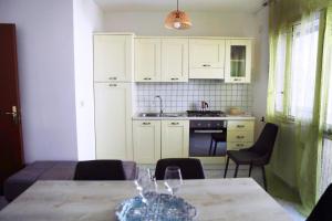 een keuken met een tafel met wijnglazen erop bij A Casa di Doralucia - Comfort a Santa Maria di Leuca in Leuca