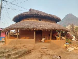 a small hut with a thatched roof in a village at Culture home, home stay in Bandīpur