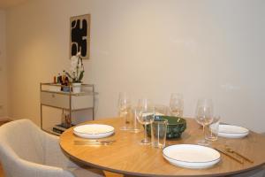 - une table en bois avec des verres et des assiettes dans l'établissement Schöner Wohnen im Zentrum von Detmold, à Detmold