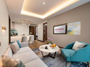 a living room with a couch and chairs and a table at Mövenpick Living West Hanoi in Hanoi +181 photos