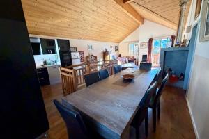 une cuisine et une salle à manger avec une grande table et des chaises en bois dans l'établissement Charming and bright cottage in Briançon, à Briançon