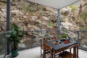een tafel en stoelen op een balkon met uitzicht op een berg bij Karst Scenic Hotel in Gaotian