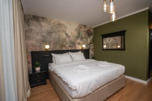 ein Schlafzimmer mit einem großen weißen Bett und einer grünen Wand in der Unterkunft Private garden room by MANAGR in Timisu de Jos