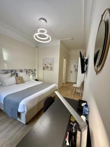 ein Schlafzimmer mit einem Bett und einem Schreibtisch mit Spiegel in der Unterkunft Hôtel Océanic - Grands Magasins in Paris