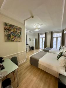 ein Hotelzimmer mit zwei Betten und einem Schreibtisch in der Unterkunft Hôtel Océanic - Grands Magasins in Paris + 72 Fotos