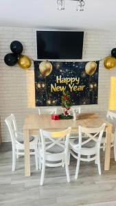 a table and chairs with a happy new year banner at BIESZCZADZKI RAJ Komfortowe domy z kominkami i Sauną na obiekcie in Olchowiec