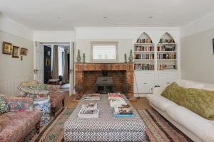 Una sala de estar con un sofá y una chimenea. en Old school house surrounded by countryside, en Earls Colne