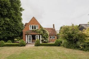 una antigua casa de ladrillo con un gran patio en Old school house surrounded by countryside, en Earls Colne