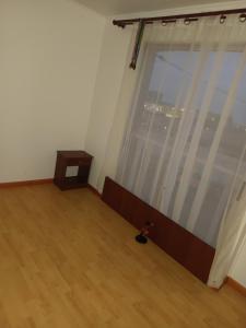an empty room with a large window and a wooden floor at novoa45 in Tocopilla