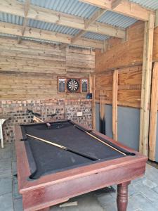 een pooltafel in een kamer met houten wanden bij Villa Kenali in Noordhoek