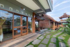 an external view of a house with large glass doors at Jawa Dwipa Villa in Wonosobo +9 photos